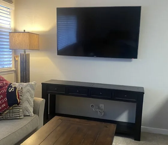 Wall-mounted TV above a console table with in-wall power concealment