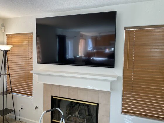 Large flat-screen TV mounted above a fireplace in Capitola