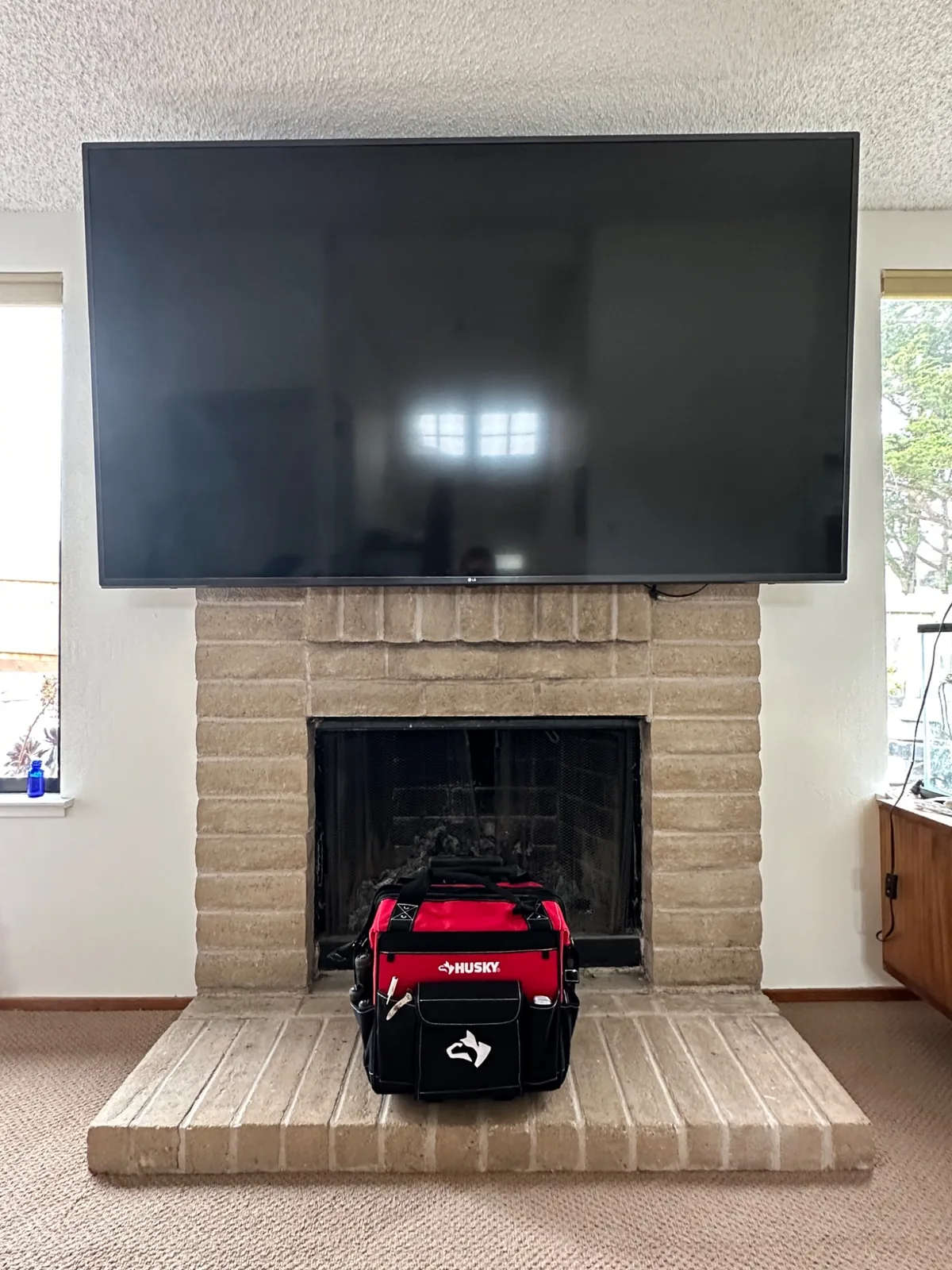75″ LG TV mounted over a fireplace in Monterey, CA