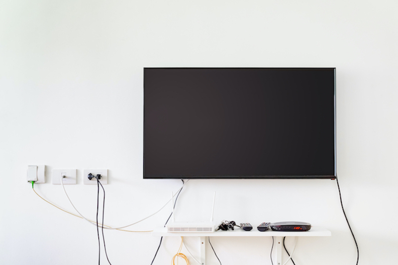 Wall-mounted TV with visible cables before cable concealment